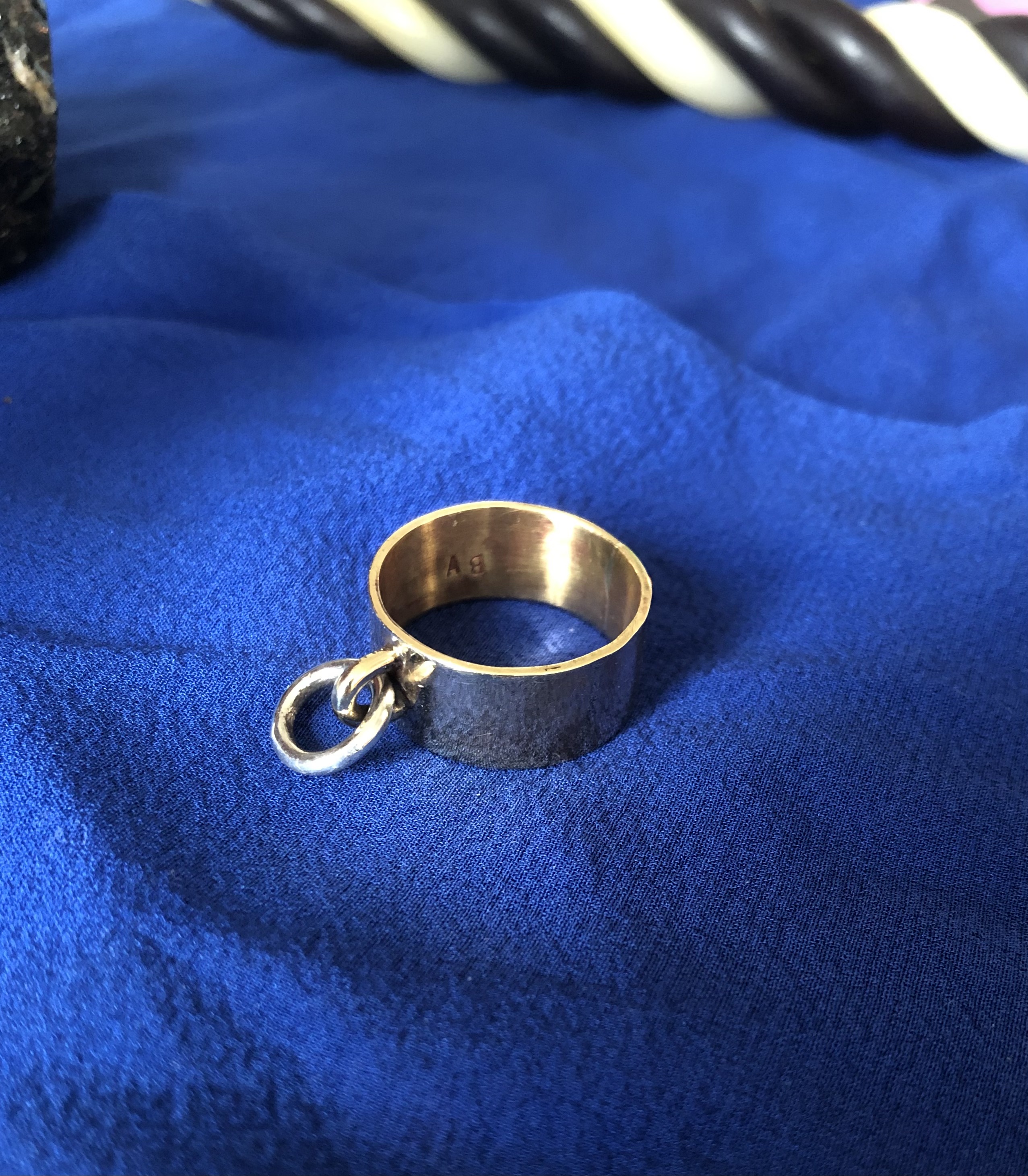 o-ring in brass and sterling silver on blue silk background
